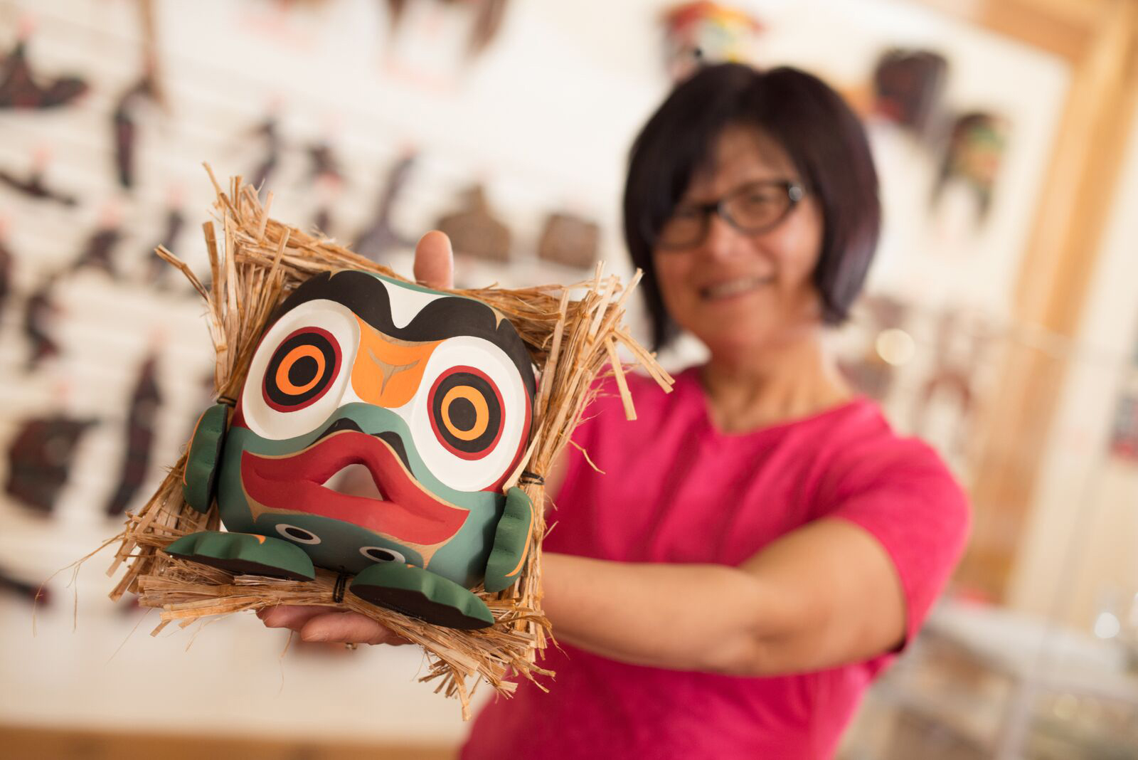 A woman holding a mask she created