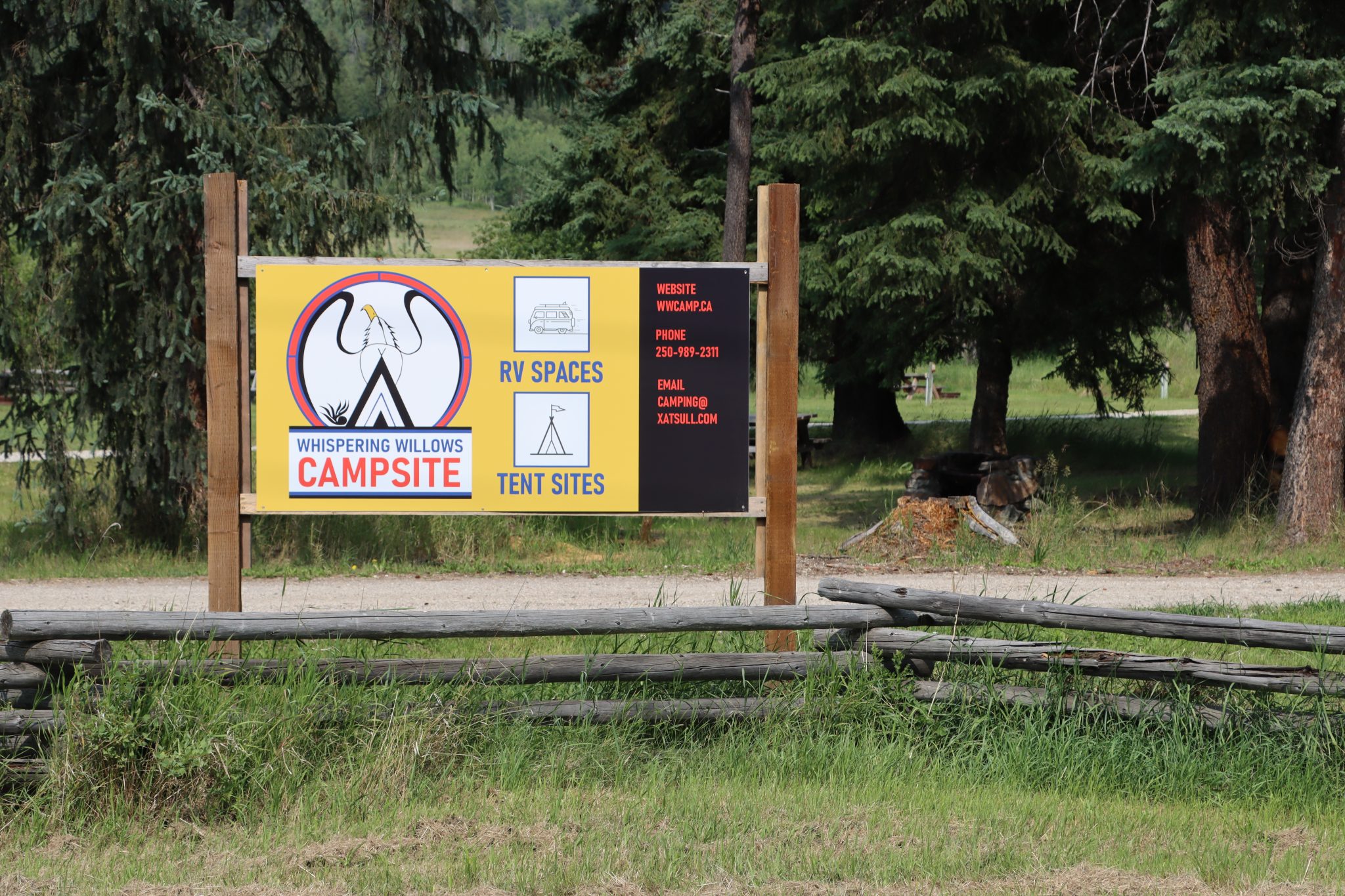 Campsite sign with trees in the background