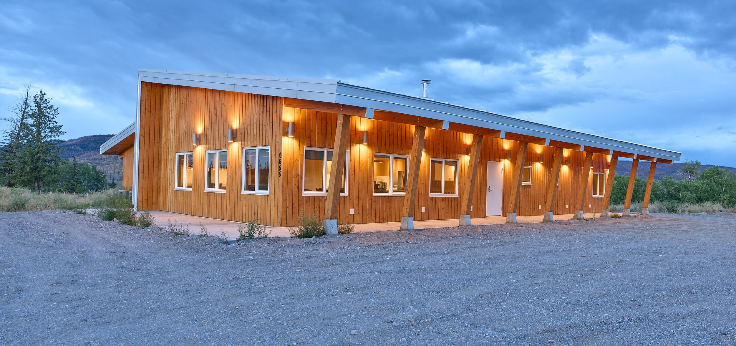 A wooden structure lit up under a dark cloudy sky