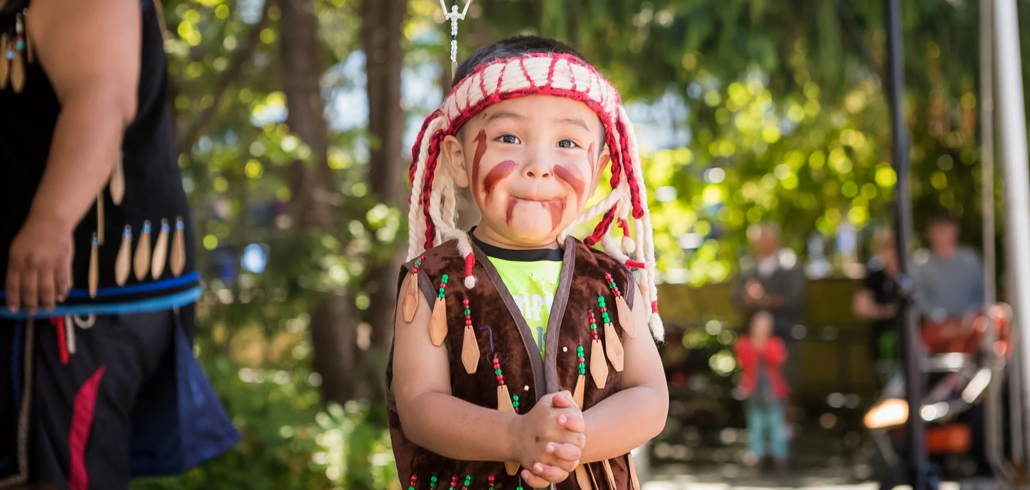 A child dressed up for a powwow.