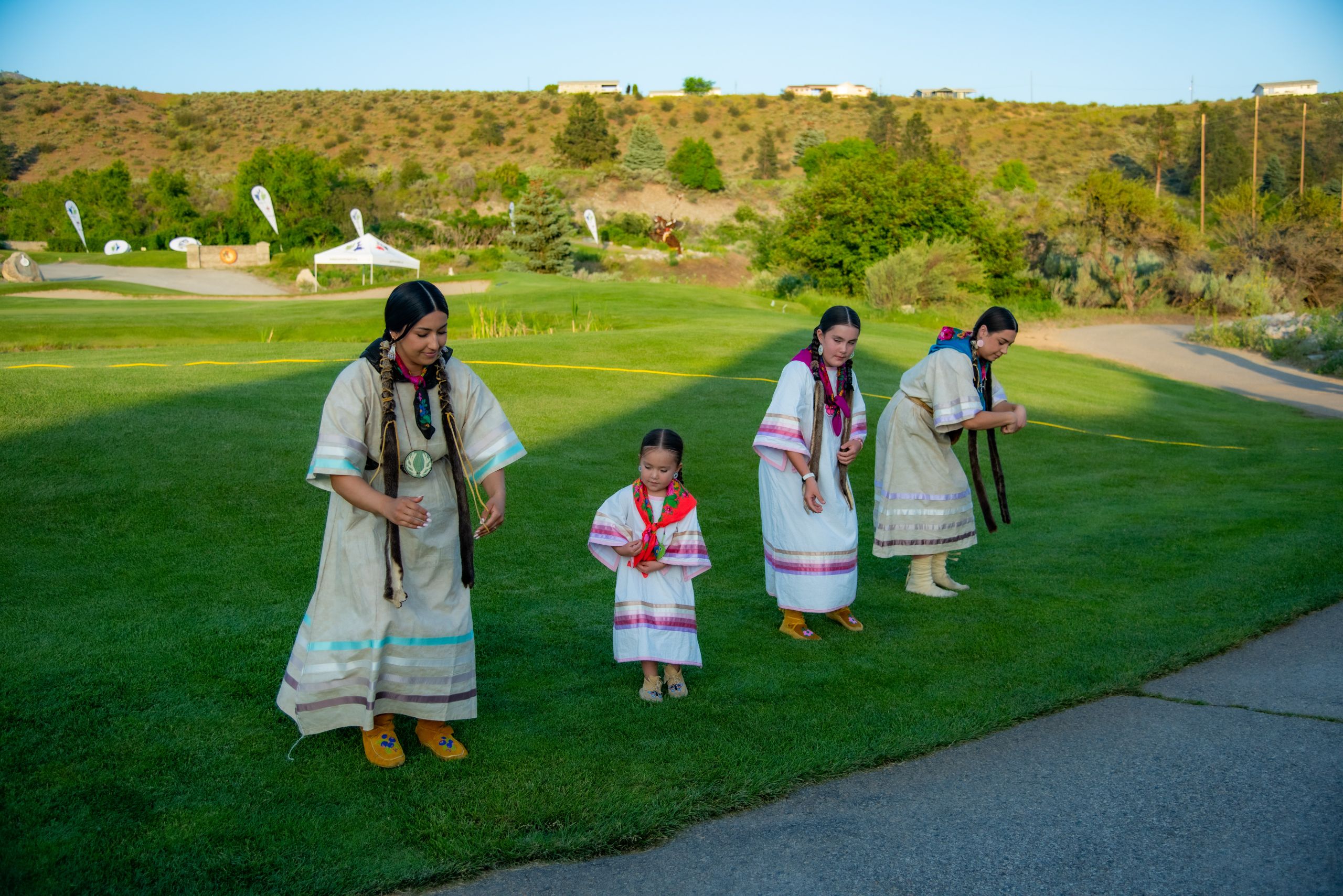 Women and children in traditional garments dancing