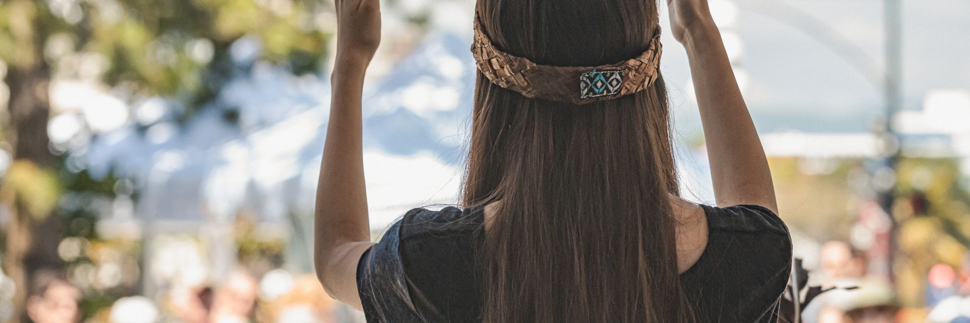 woman's back of her head while she is performing to a crowd.