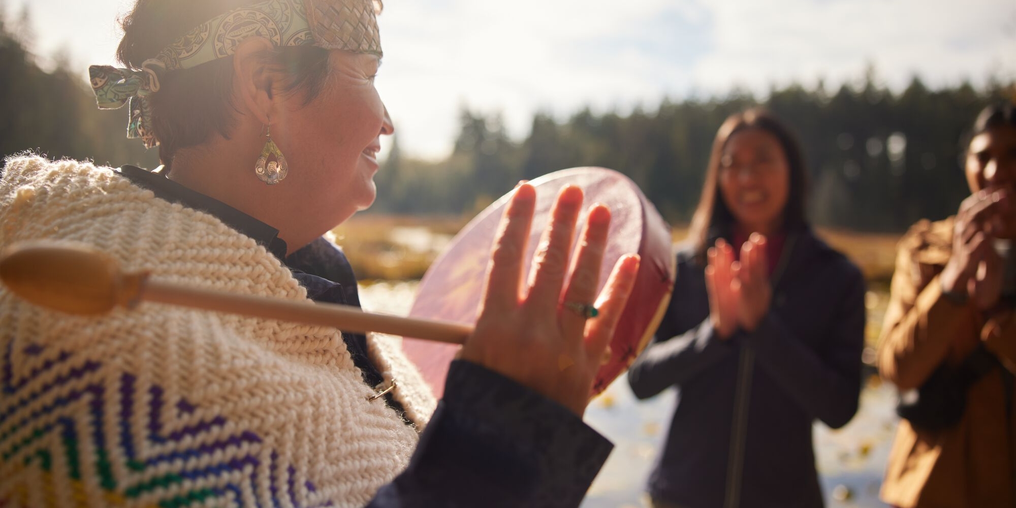 A woman playing the drum in front of a crowd