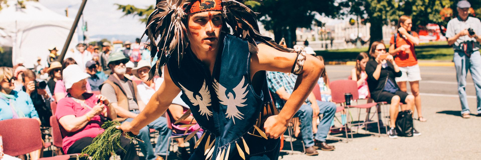 A man dressed in traditional clothing dancing in a Powwow