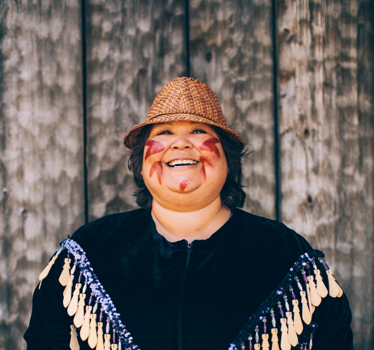 Woman wearing traditional clothing with a drum