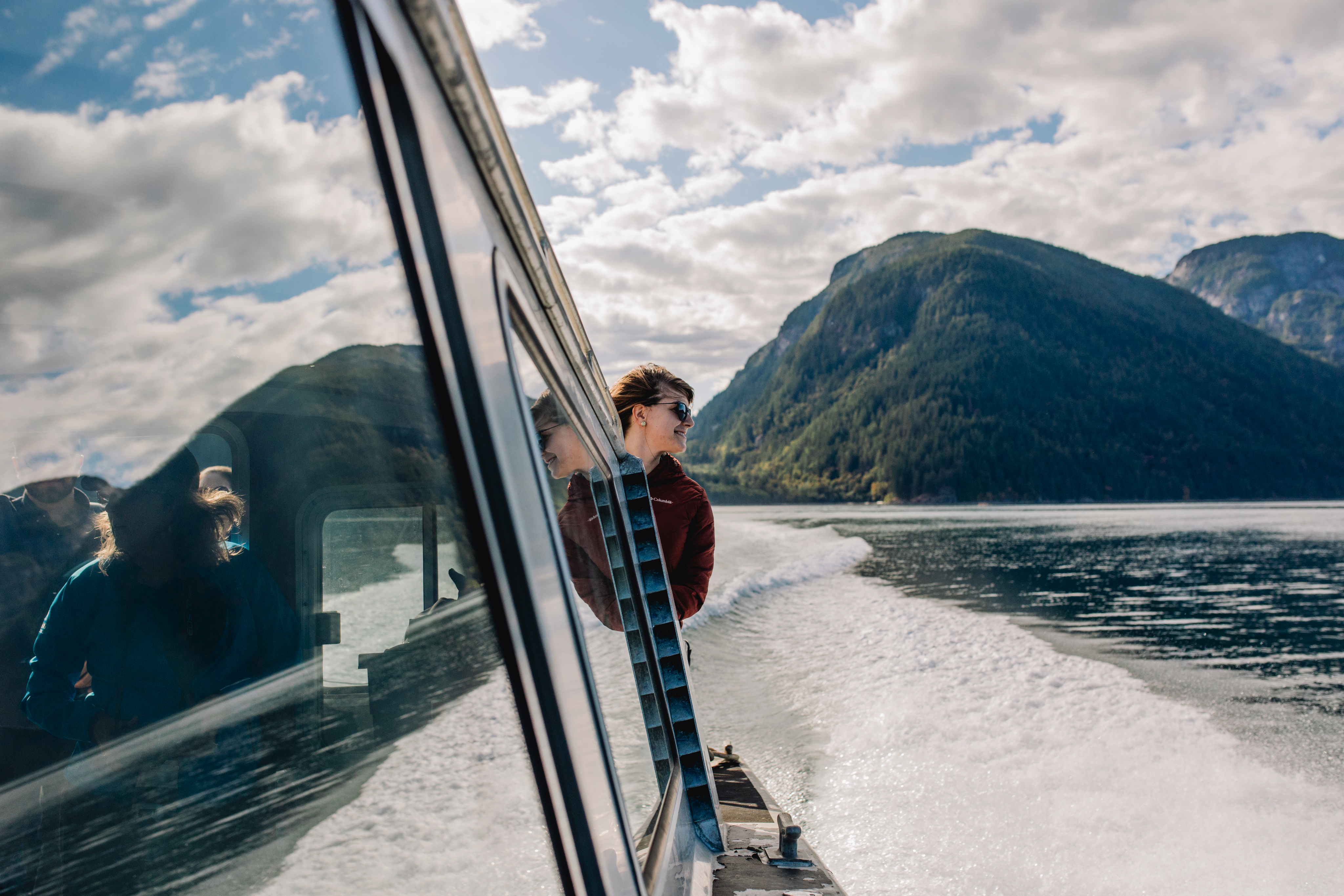 People on a boat in the water with mountains in the background