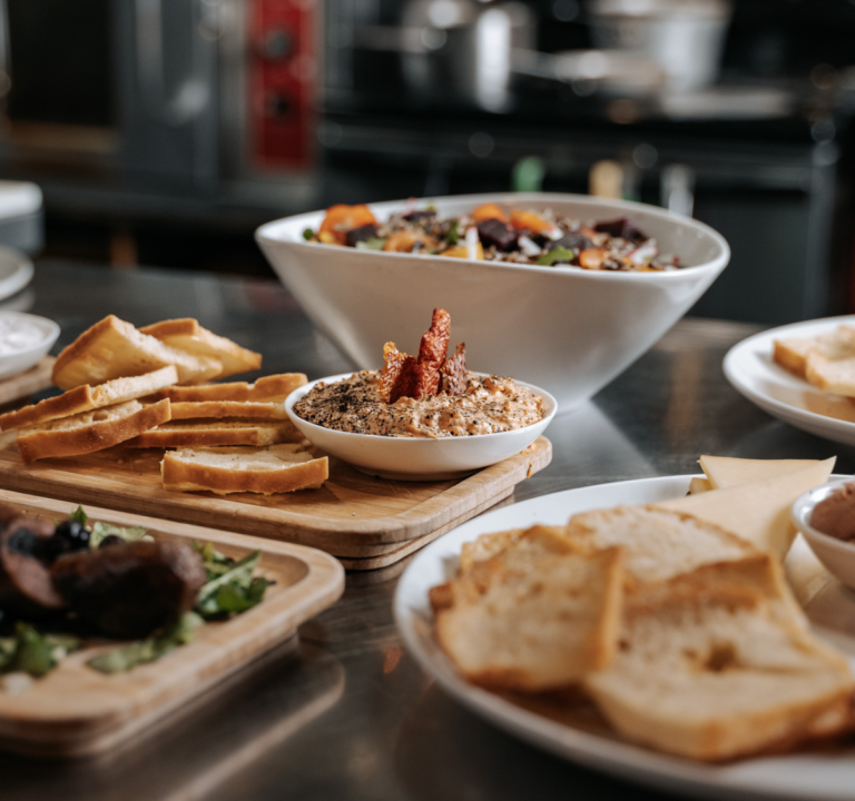 A spread of dips, salads, and meats on a restaurant table