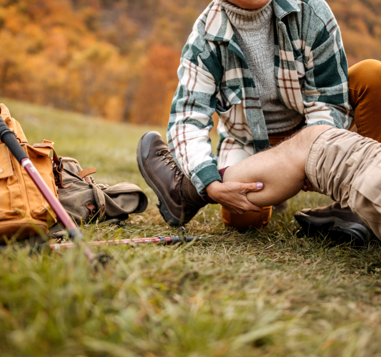 A man helping a hiker out with a leg injury